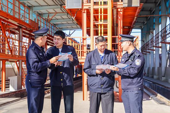 刑警支隊民警向企業(yè)職工發(fā)放宣傳資料并“一對一”講解電詐常識。謝仁古力·托呼提 攝